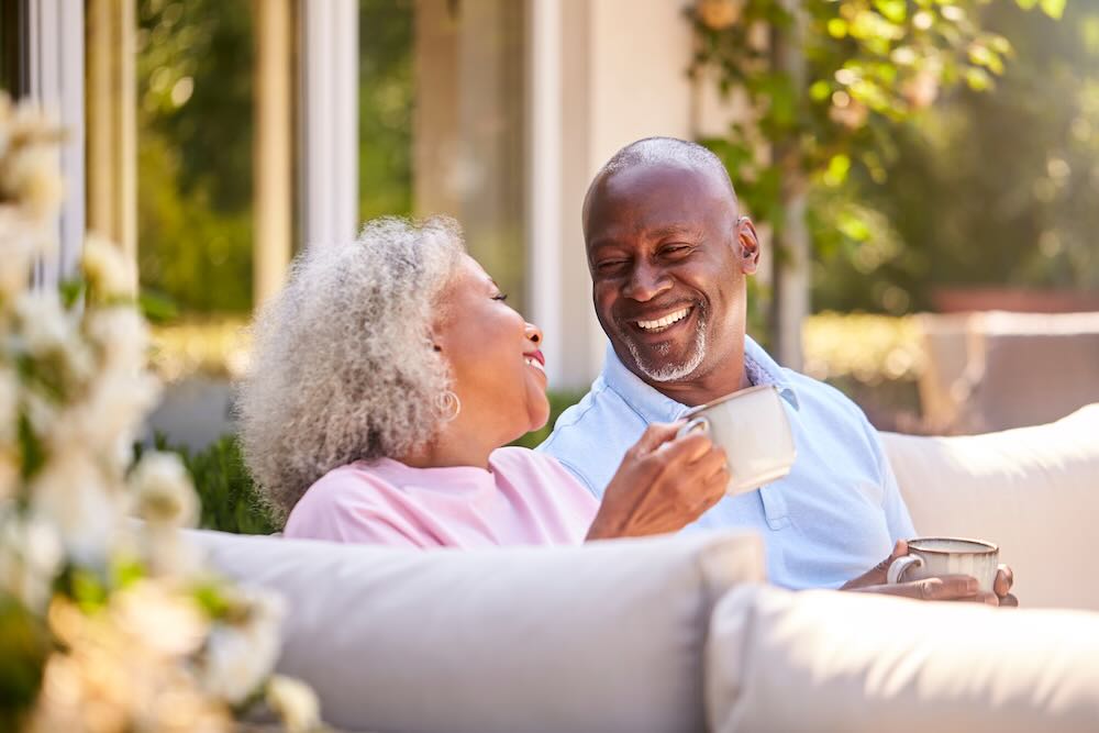 Senior couple having a coffee in their backyard 